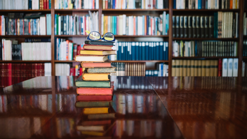 Pila de libros con gafas sobre ella.